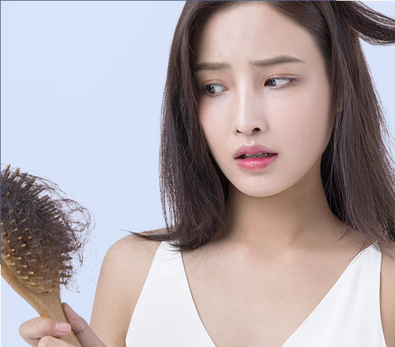 Woman worried about thinning hair holding a hairbrush